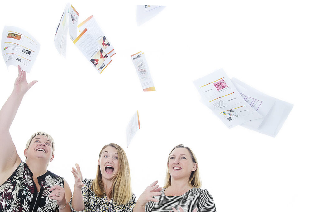 People throwing accounting documents into the air with laughter